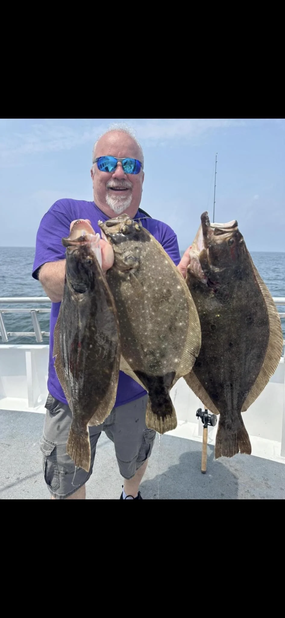 Don holding three fluke from a fishing trip